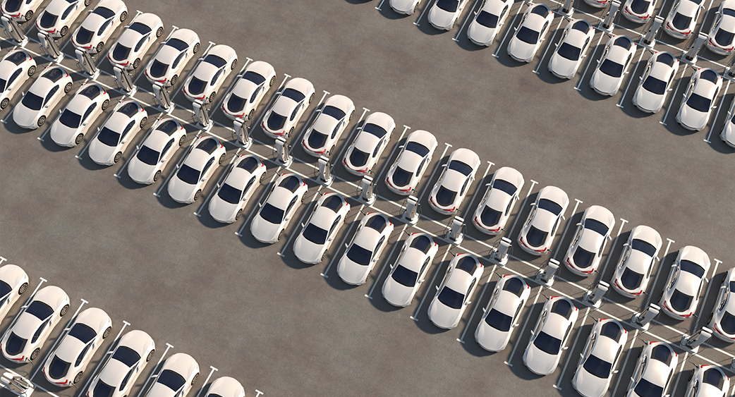 Several white EVs parked and charging